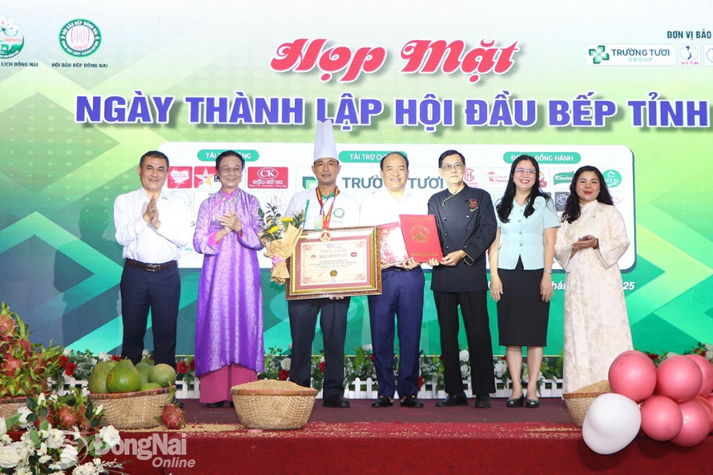 Ủy viên Ban Thường vụ Tỉnh ủy, Phó Chủ tịch UBND tỉnh Đồng Nai Lê Trường Sơn (bìa trái); Tỉnh ủy viên, Giám đốc Sở Văn hóa, Thể thao và Du lịch Đồng Nai Lê Thị Ngọc Loan (thứ 2, từ phải qua) cùng Tổ chức Kỷ lục Việt Nam trao kỷ lục Xôi chiên phồng hạt điều lớn nhất Việt Nam cho Chi hội Đầu bếp tỉnh Đồng Nai. Ảnh: Ngọc Liên