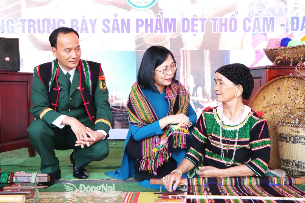 Đại tá Võ Thành Danh, Ủy viên Ban Thường vụ Tỉnh ủy, Chỉ huy trưởng Bộ Chỉ huy Quân sự tỉnh Đồng Nai và Tỉnh ủy viên, Phó Chủ tịch UBND tỉnh Nguyễn Thị Hoàng trao đổi với đồng bào M’nông tại xã Bù Gia Mập về nghề dệt thổ cẩm. Ảnh: Ngọc Liên