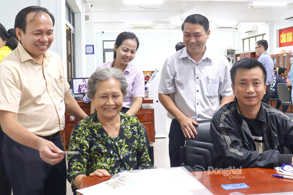 Phó Giám đốc Sở Nội vụ tỉnh Đồng Nai Hà Thanh Tùng (bìa trái) trực tiếp hỗ trợ người dân giải quyết thủ tục hành chính tại Trung tâm Phục vụ hành chính công xã Nhơn Trạch. Ảnh: Nguyệt Hà