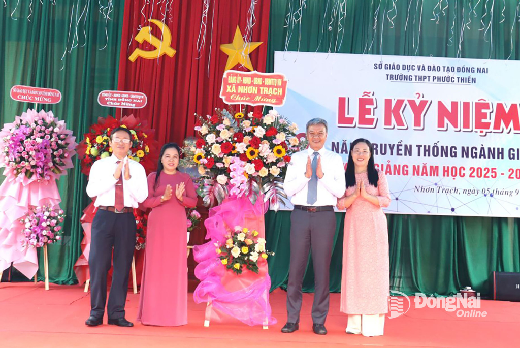 Tỉnh ủy viên, Bí thư Đảng ủy, Chủ tịch HĐND xã Nhơn Trạch Từ Nam Thành tặng hoa chúc mừng nhà trường. Ảnh: Nguyệt Hà