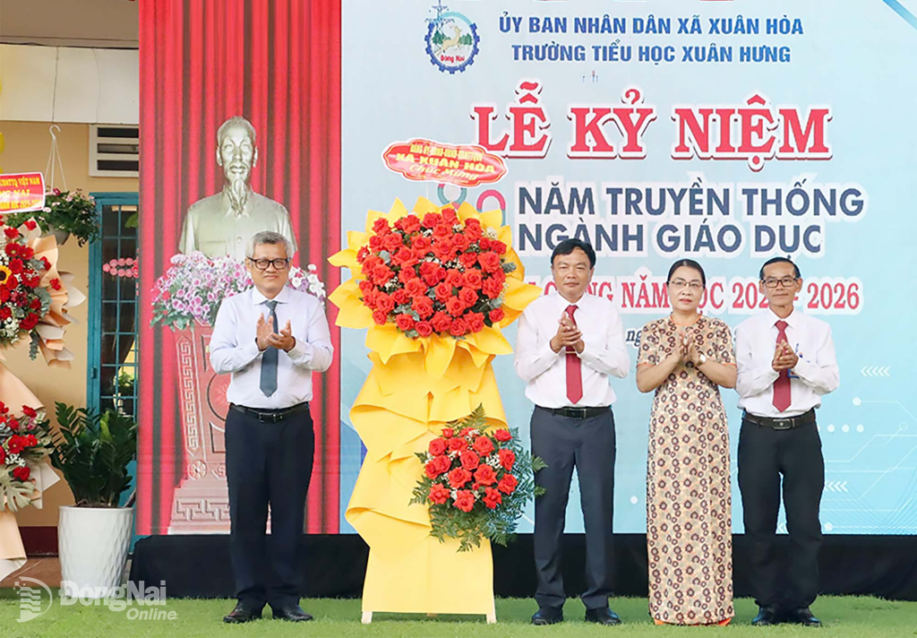 Bí thư Đảng ủy, Chủ tịch HĐND xã Xuân Hòa Tạ Quang Trường tặng lẵng hoa chúc mừng tập thể Trường Tiểu học Xuân Hưng. Ảnh: Văn Đoàn
