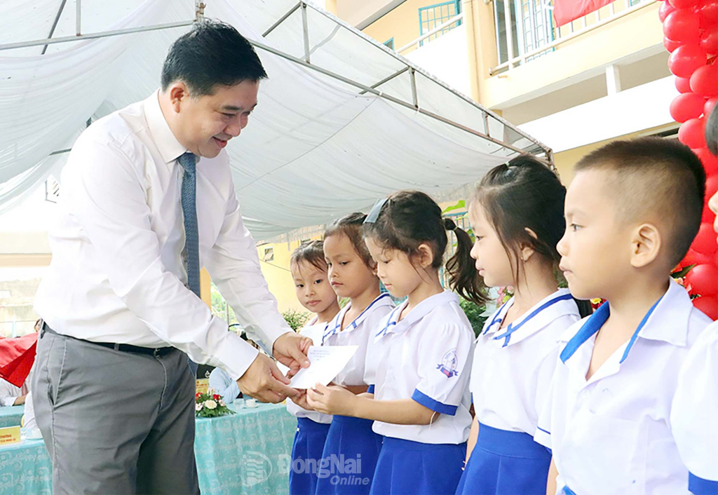 Tỉnh ủy viên, Phó Chủ tịch UBND tỉnh Đồng Nai Hồ Văn Hà trao học bổng cho học sinh của Trường Tiểu học Xuân Hưng. Ảnh: Văn Đoàn